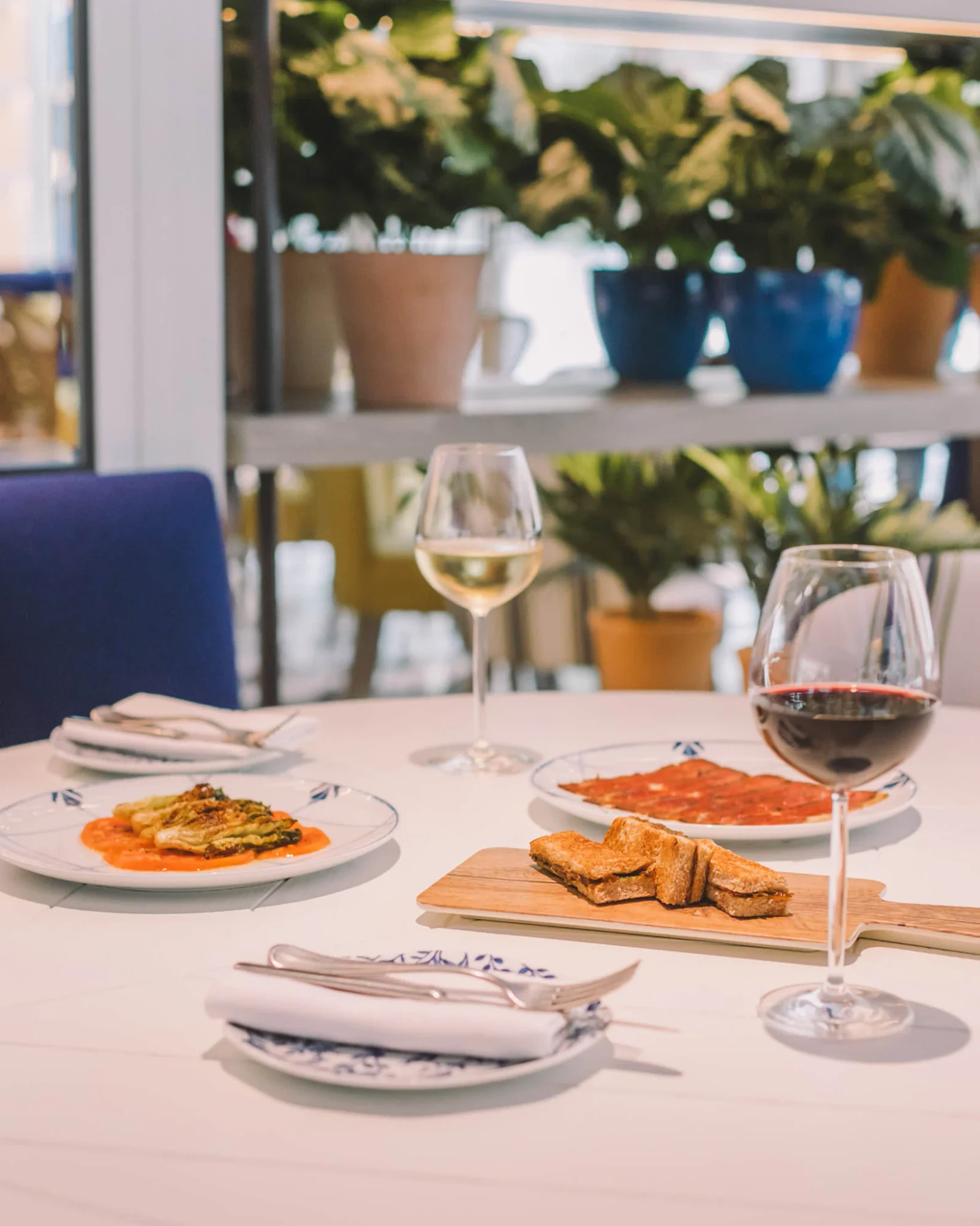 Two plates and a glass of wine set out at The Kitchen