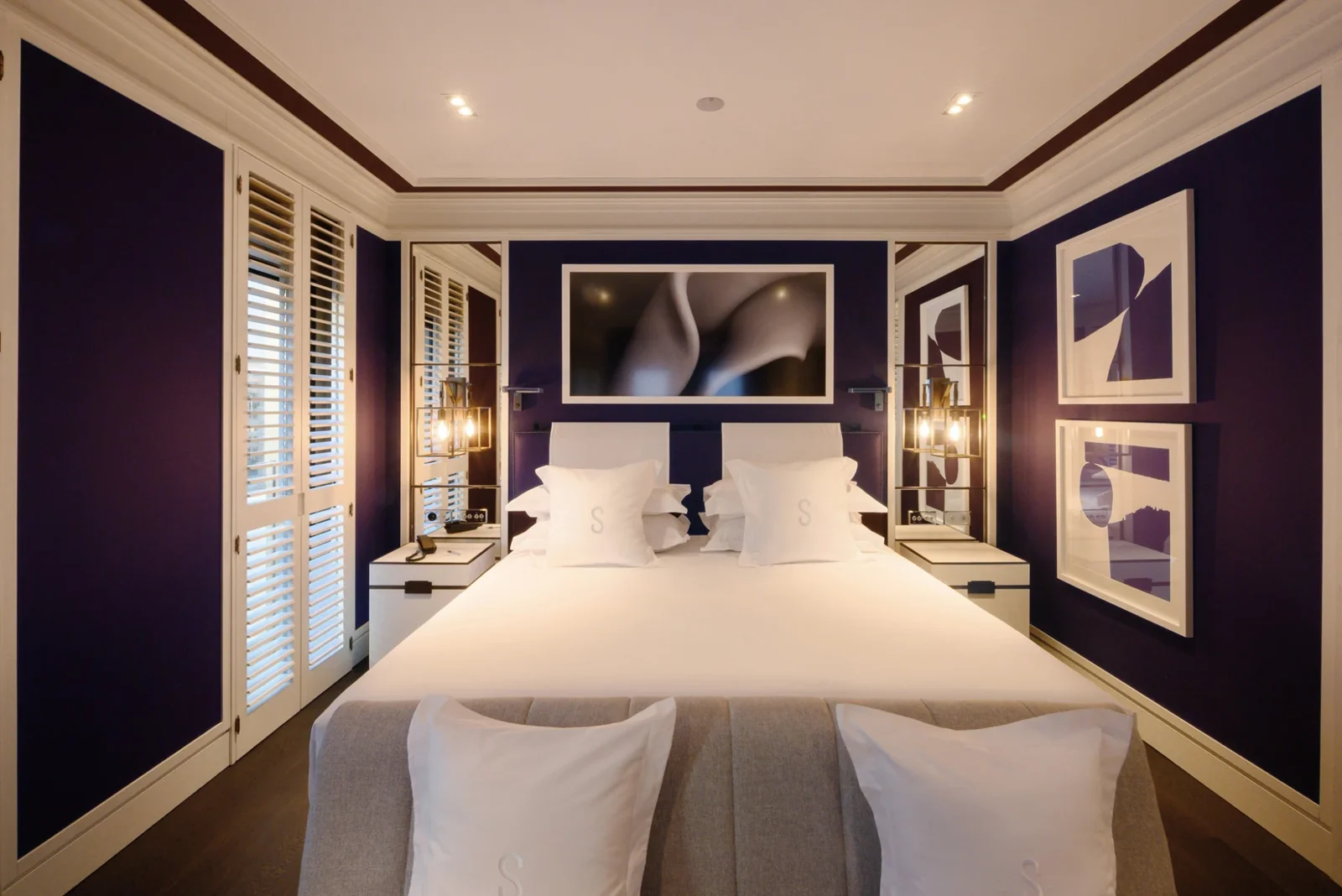 Twin beds against the navy panelled headboard of a Seventy Room