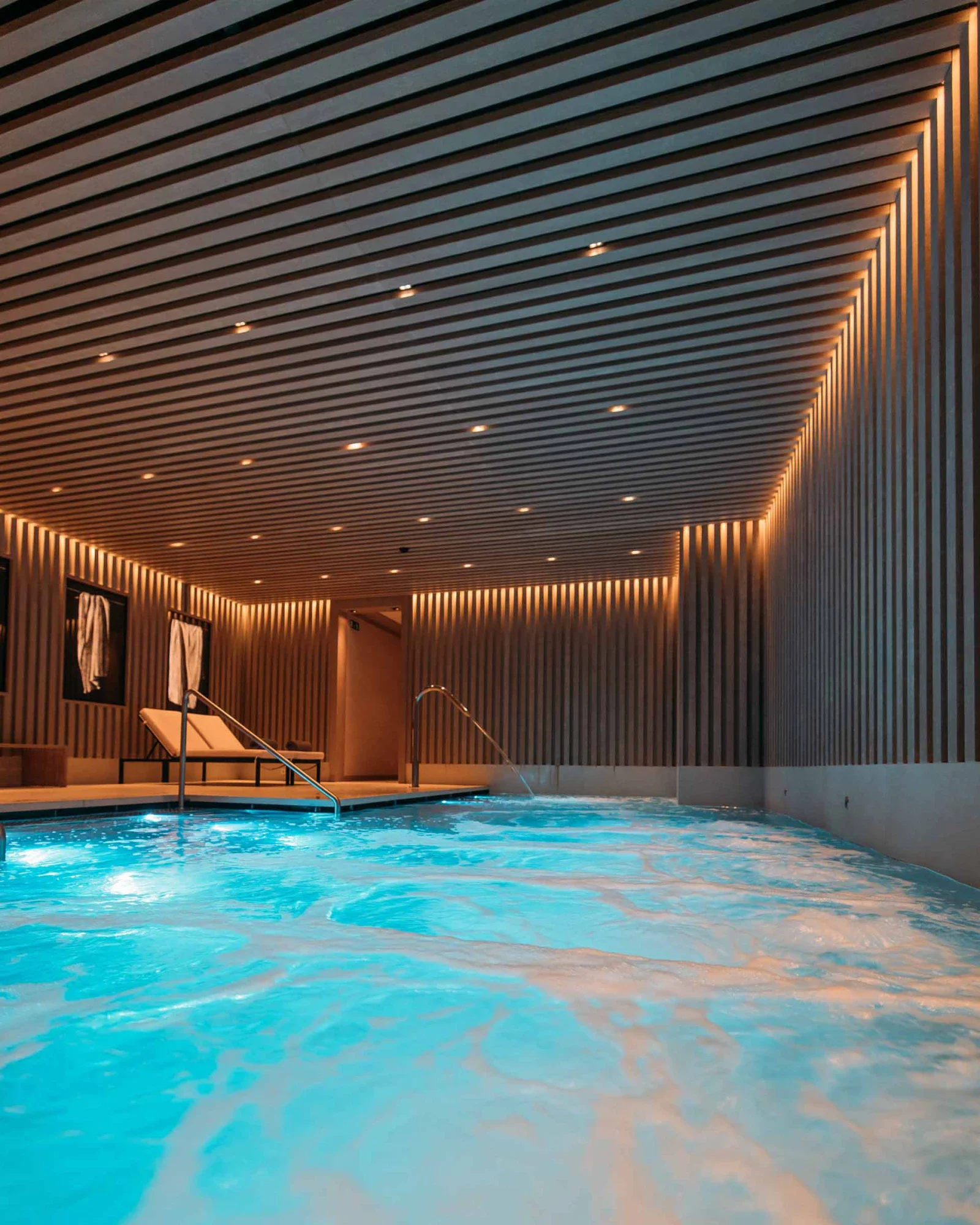 The lit indoor pool at Seventy Spa, under its slatted timber ceiling